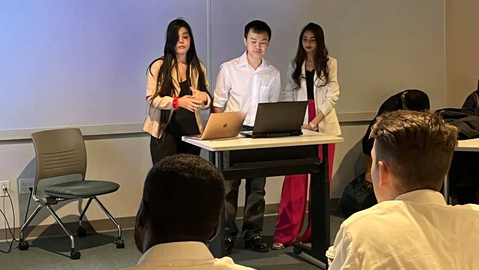 Three 麻豆国产精品 Students standing at front of classroom and presenting. 